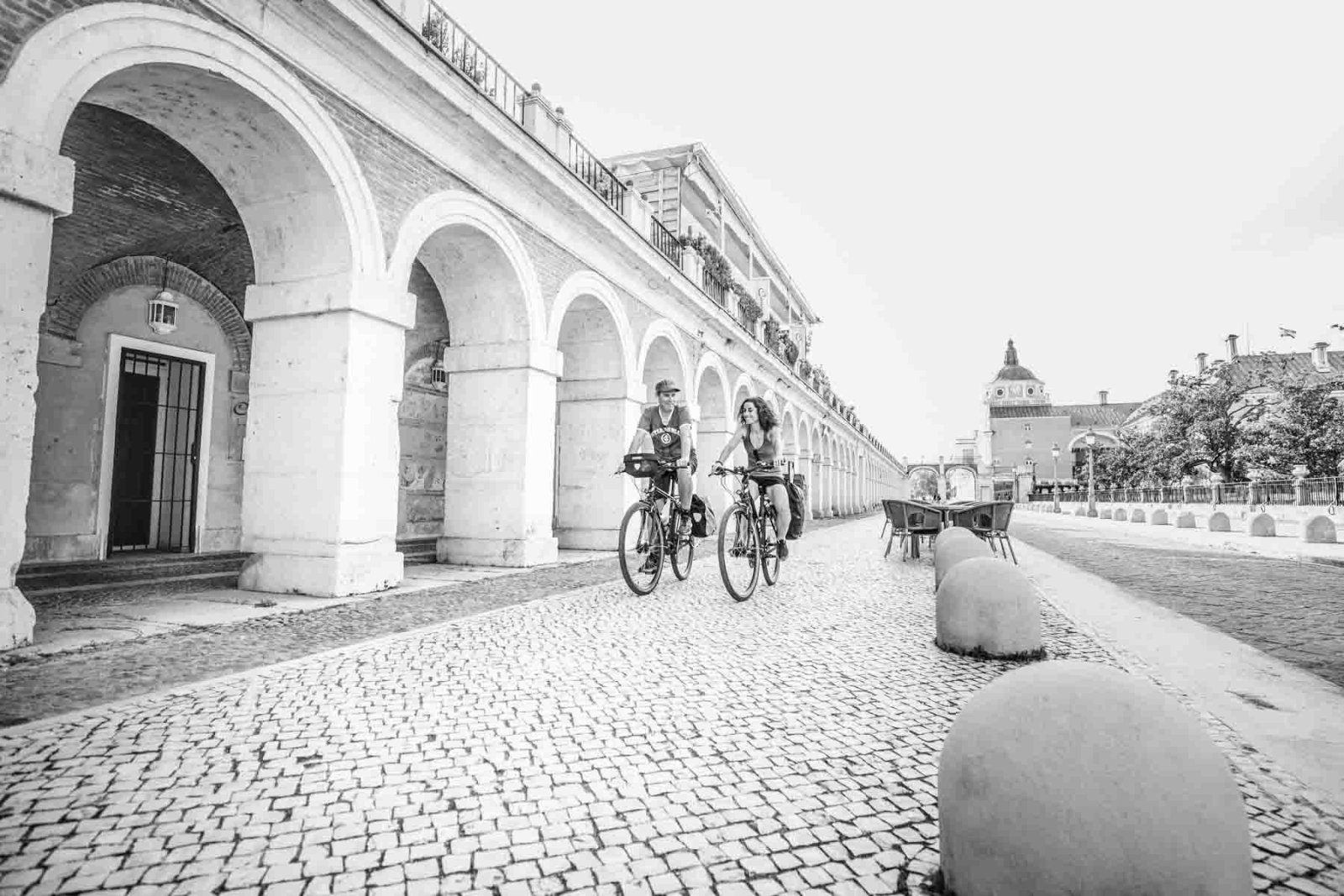 Ciclistas bajo los arcos en blanco y negro
